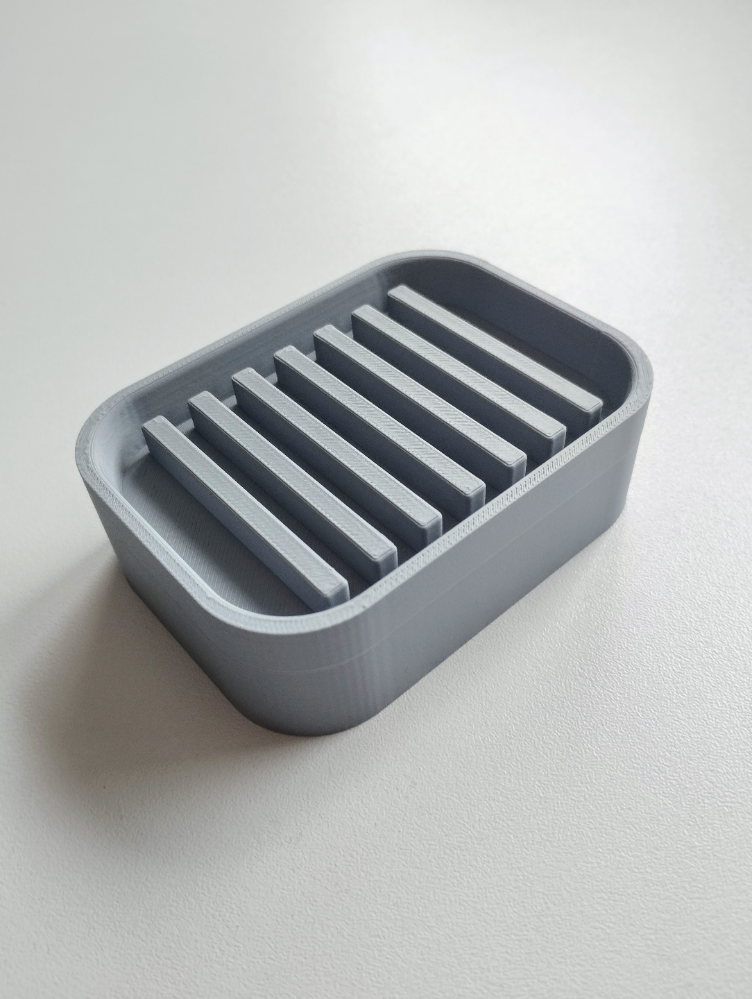 Détail d'un porte-savon minimaliste avec pente d'écoulement et bord fin