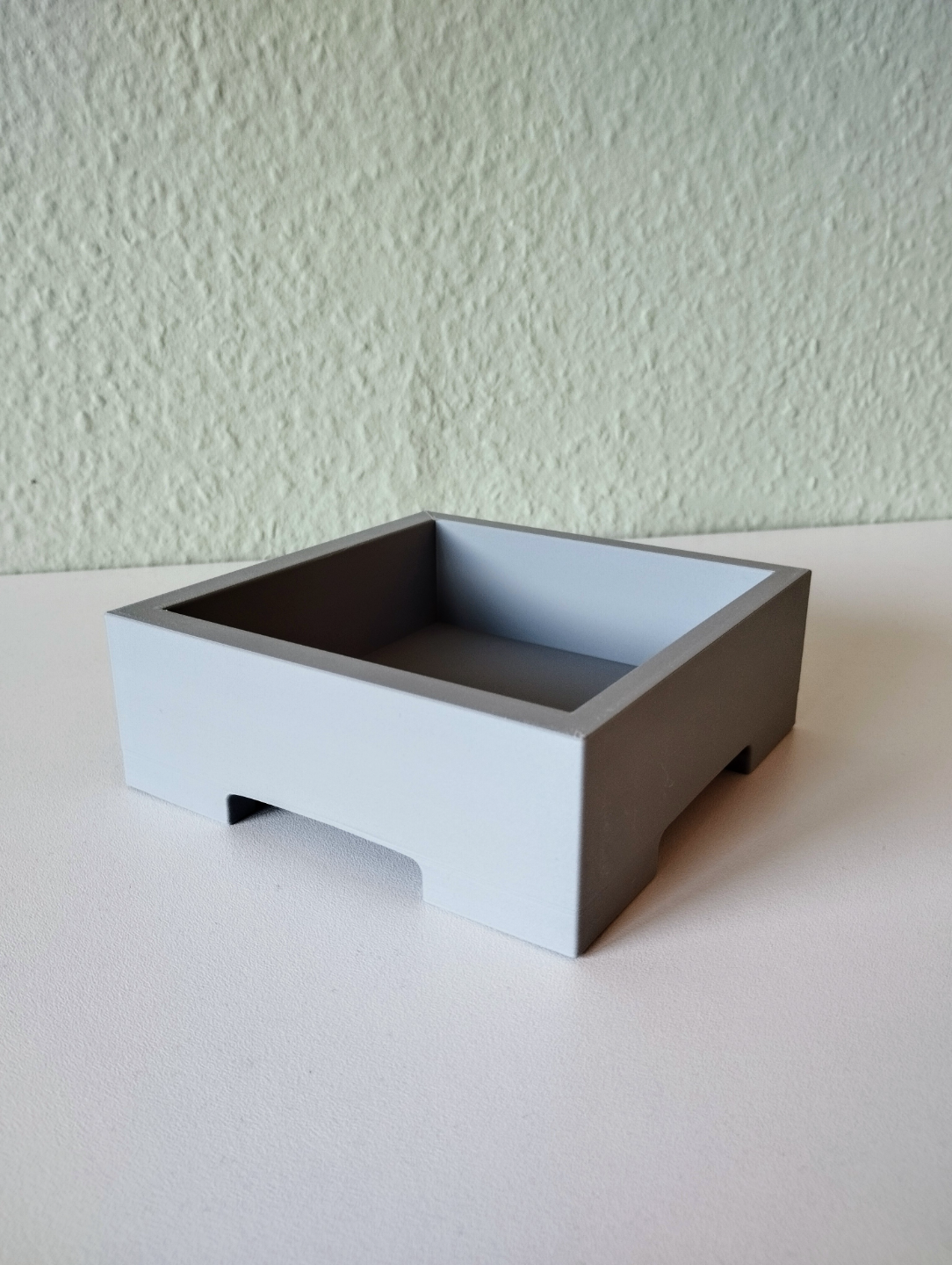 Pot à bonsaï minimaliste avec une petite plante sur une étagère en bois clair