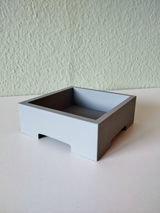 Pot à bonsaï minimaliste avec une petite plante sur une étagère en bois clair