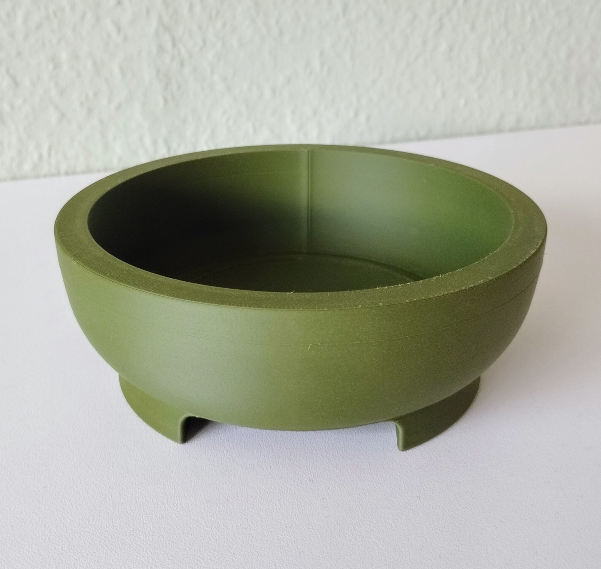 Gros plan d'un pot à bonsaï rond à forme géométrique épurée et pied intégré