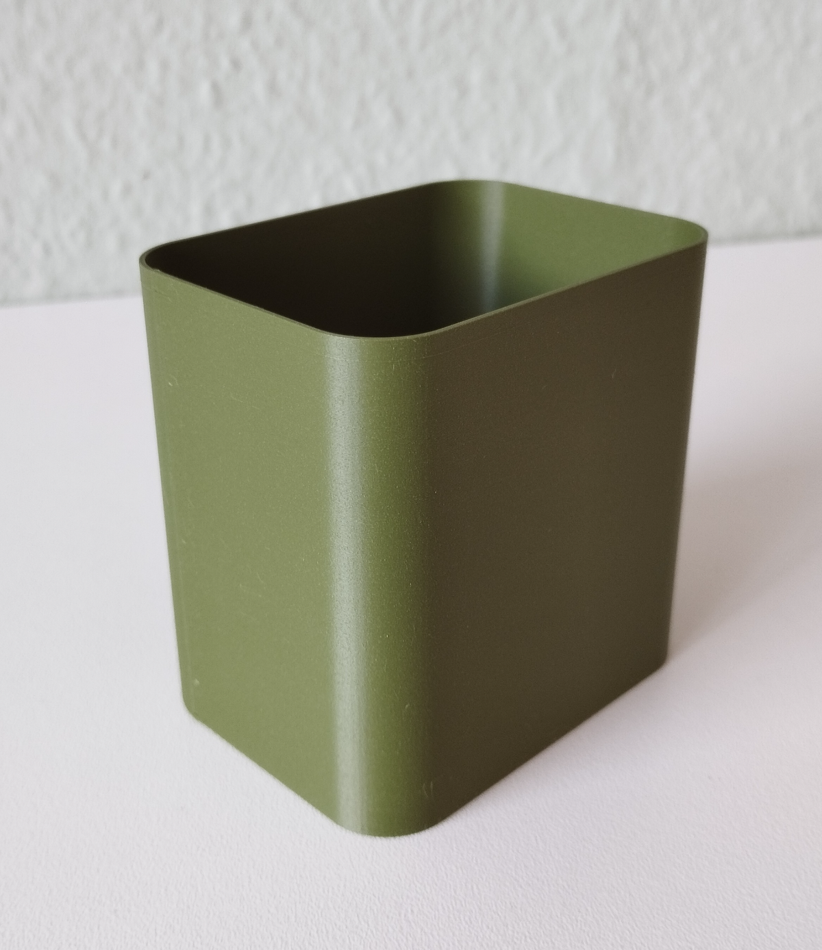 Pot à crayons minimaliste sur un bureau avec des stylos et des carnets