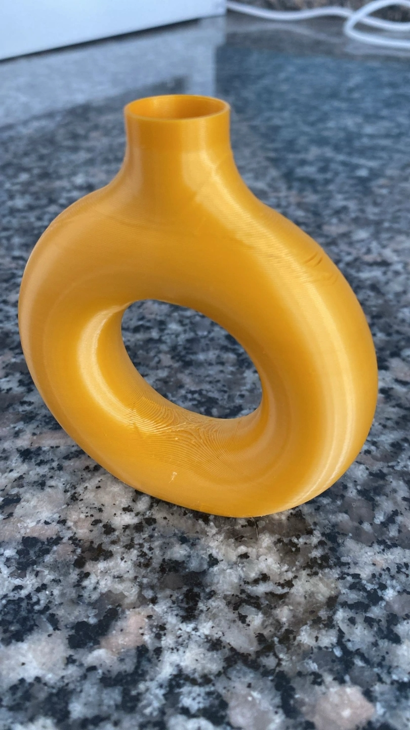 Vase rond et creux sur une étagère en bois avec tiges séchées