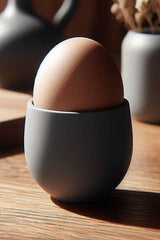 Coquetier blanc moderne, gros plan en biais sur la forme effilée et épurée