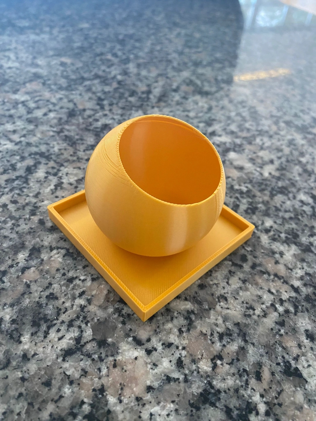 The Ball – range-télécommande minimaliste sur une table d'appoint au salon avec télécommande et feuille