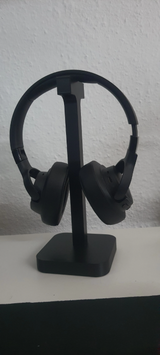 Support pour casque sur un bureau près d'un écran et d'une lampe de bureau