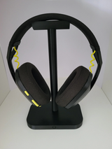 Support de casque minimaliste sur un bureau à côté d'un écran et d'une lampe