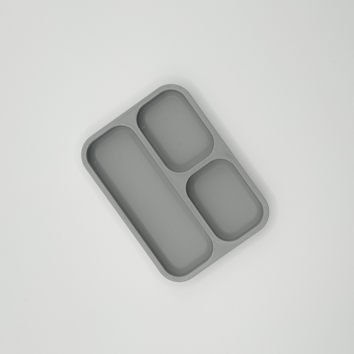 Détail des lignes géométriques d'un vide-poche minimaliste pour clés et pièces