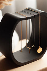 Porte-collier incurvé avec une fine chaîne drapée dessus