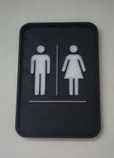Détail de la typographie nette et de la finition neutre de la plaque de toilettes