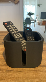 Range-télécommandes sur une table d'appoint de salon avec une tasse de café et une plante