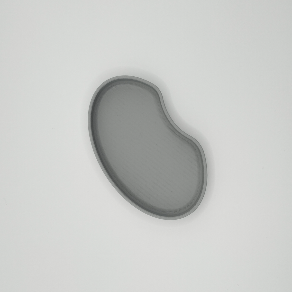 Détail du bord doux et de la silhouette minimaliste d'un plateau en forme de haricot