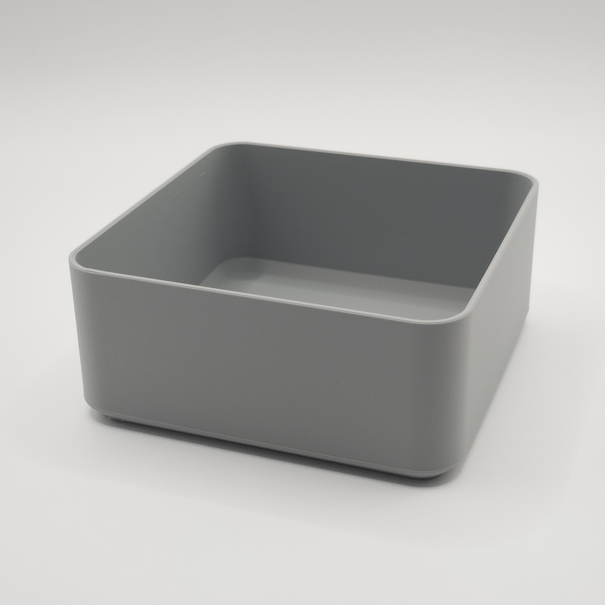 Bol carré blanc minimaliste sur une table basse en bois avec télécommande et clés