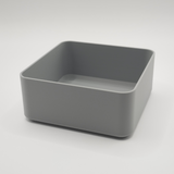 Bol carré blanc minimaliste sur une table basse en bois avec télécommande et clés