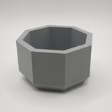 Détail du bord octogonal d'un pot de fleurs minimaliste sous une lumière douce
