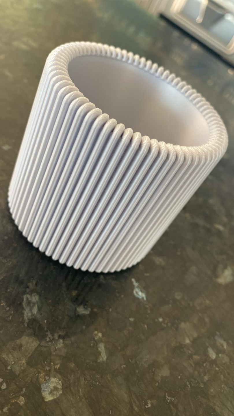 Gros plan d'un pot à crayons cannelé à rainures verticales plates et au design minimaliste