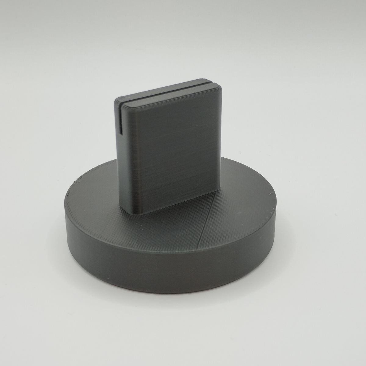 Porte-photo minimaliste sur un bureau en bois à côté d'une plante en pot
