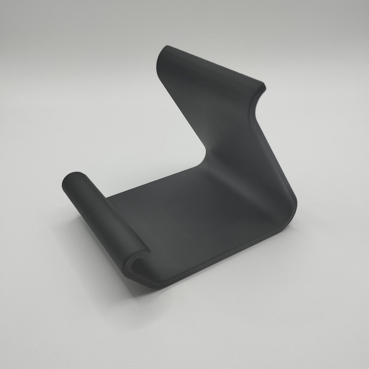 Support de téléphone incurvé sur un bureau en bois avec un iPhone