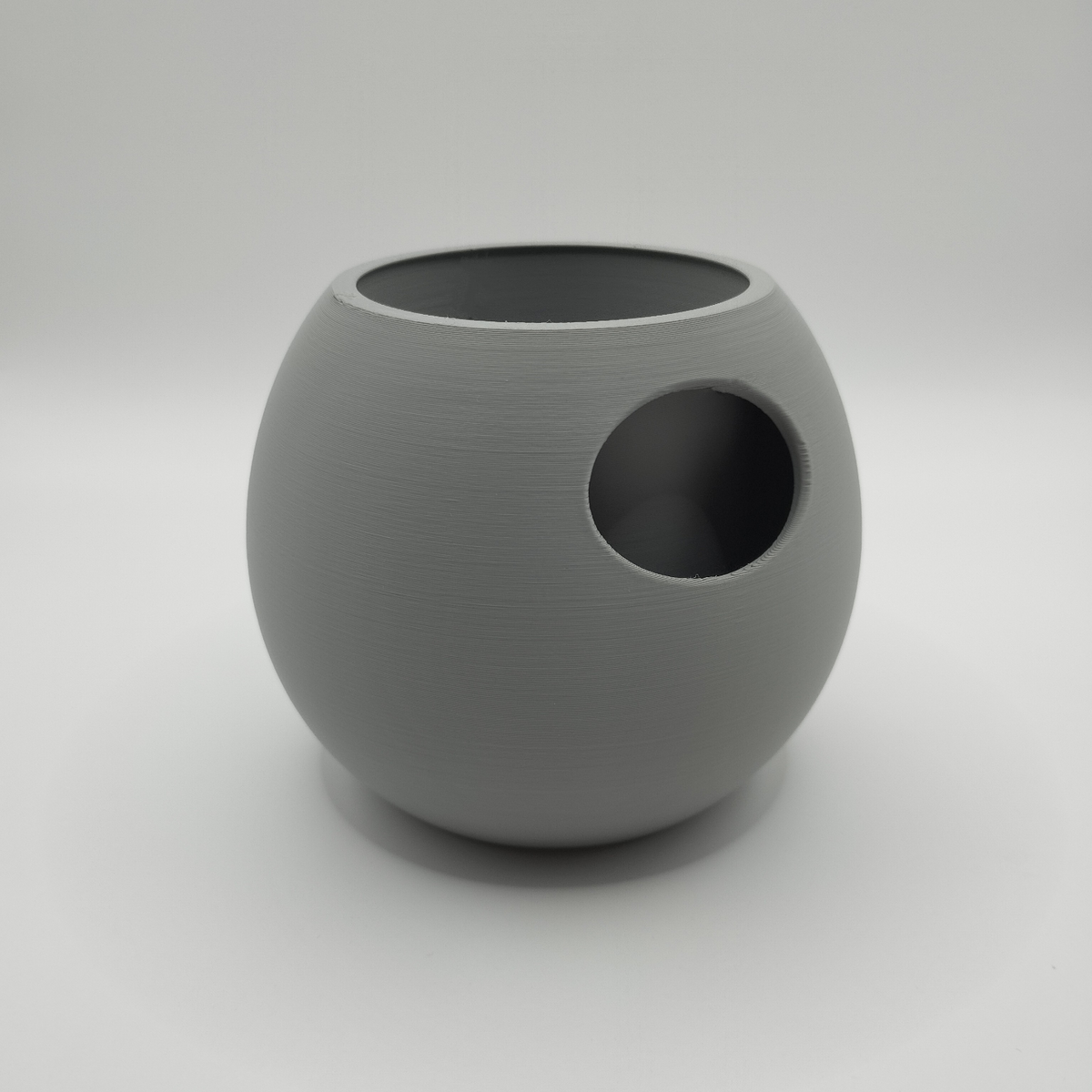 Pot de fleurs à réserve d'eau sur une étagère blanche parmi d'autres décorations, intérieur scandinave