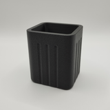 Pot à crayons minimaliste sur un bureau en bois avec des stylos et un carnet