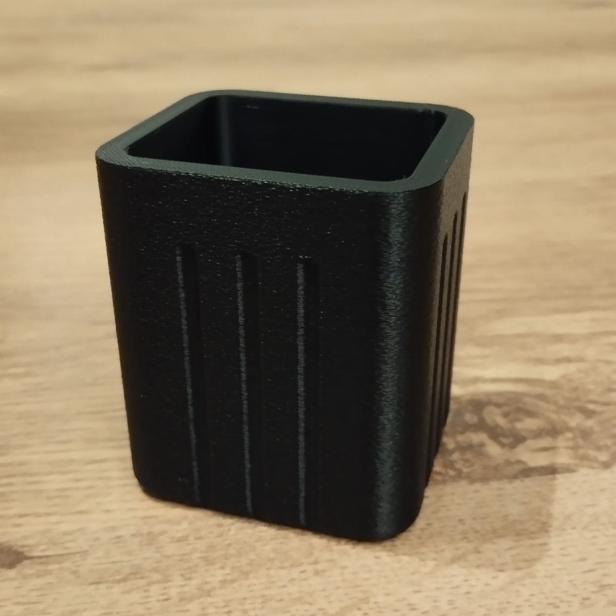 Gros plan d'un pot à crayons carré minimaliste aux côtés rainurés