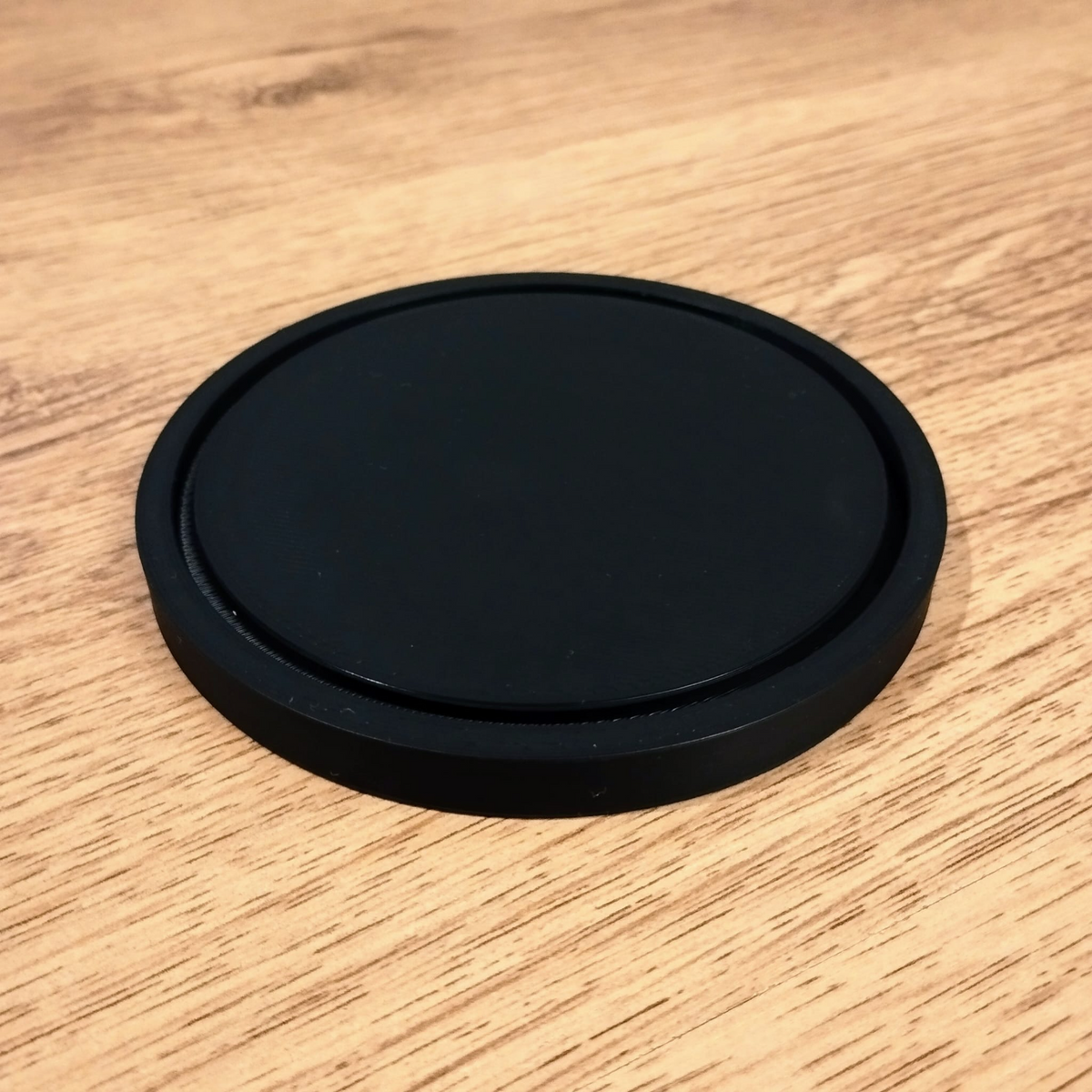 Sous-verre rond minimaliste et lisse vu de dessus, géométrie épurée et surface mate