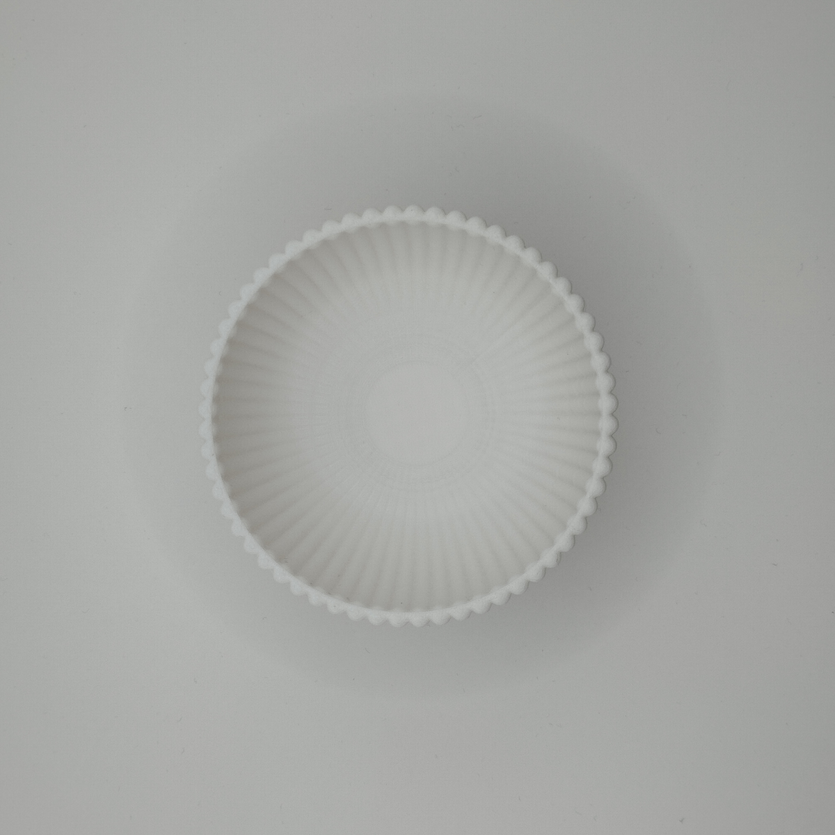Une lumière douce sur le bol strié crée un jeu d'ombres