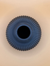 Détail d'un vase cannelé qui capte la lumière