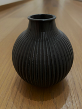 Gros plan d'un vase cannelé aux lignes verticales sur une forme ronde