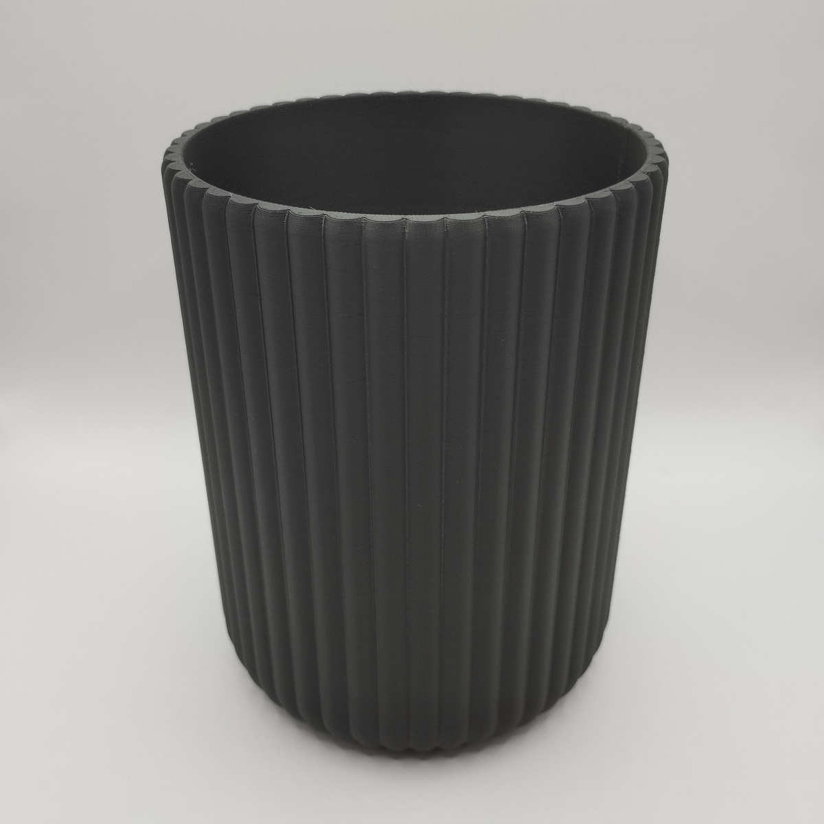 Surface striée d'un pot à ustensiles dans la lumière, détail de la texture