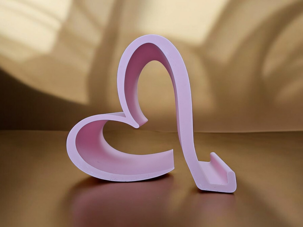 Support de téléphone Saint-Valentin sur un bureau près d'un smartphone et d'un carnet
