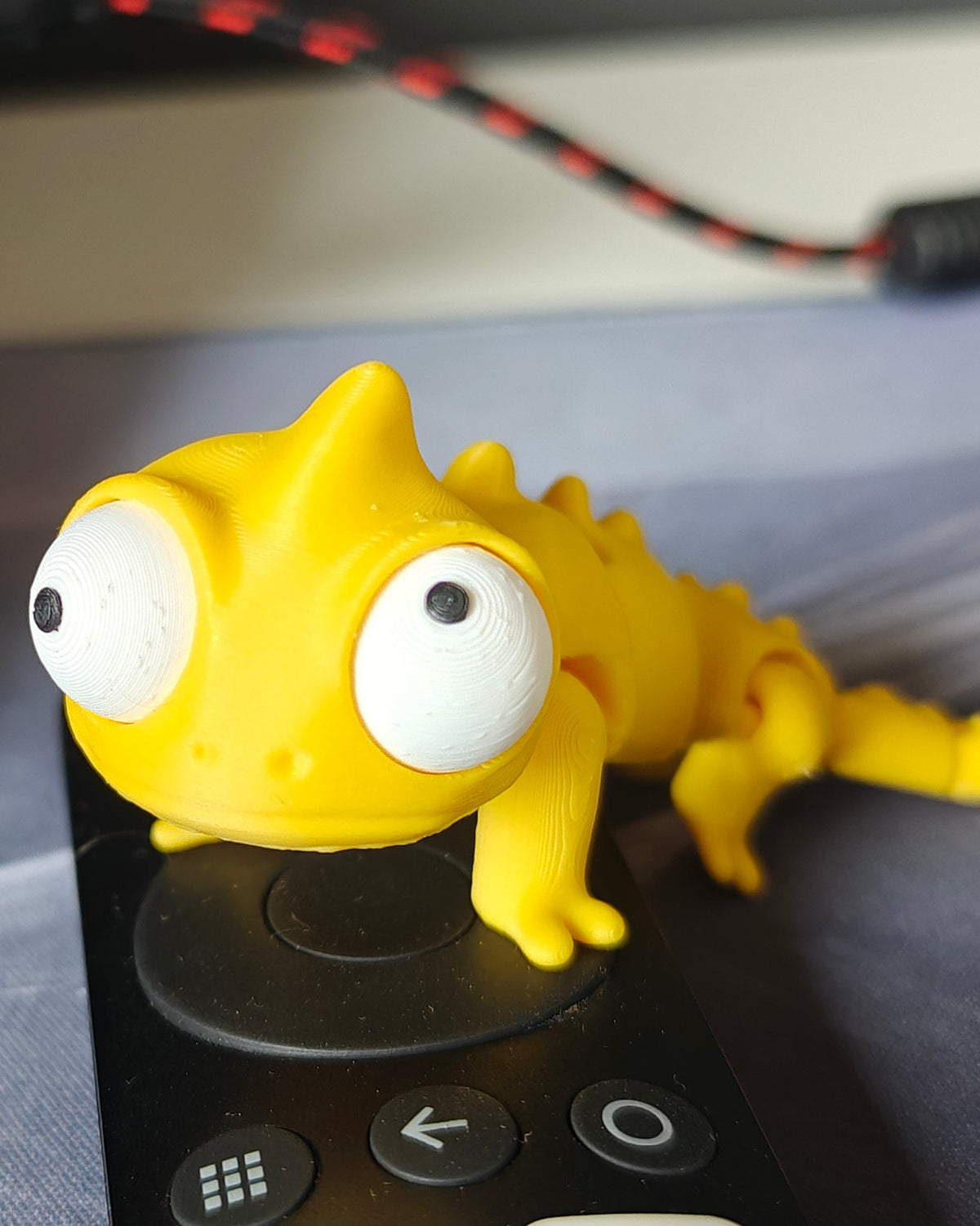 Caméléon articulé aux grands yeux mobiles sur fond blanc