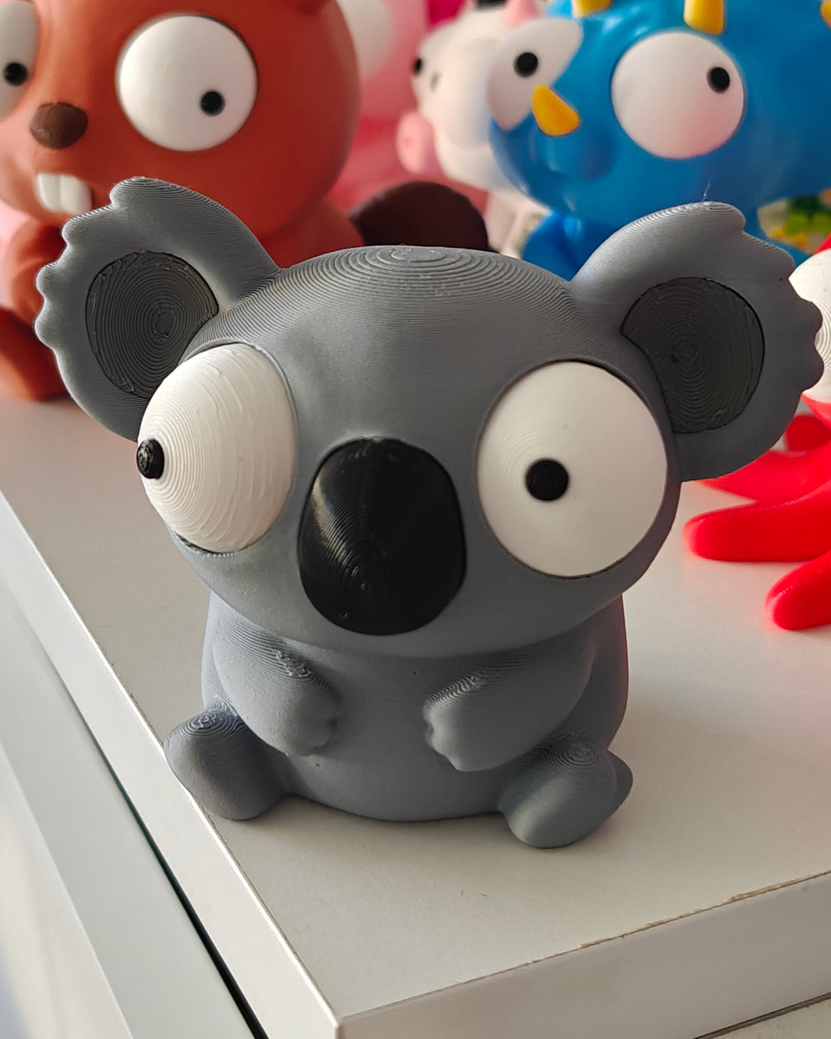 Gros plan des grands yeux mobiles de la figurine de koala aux différentes expressions