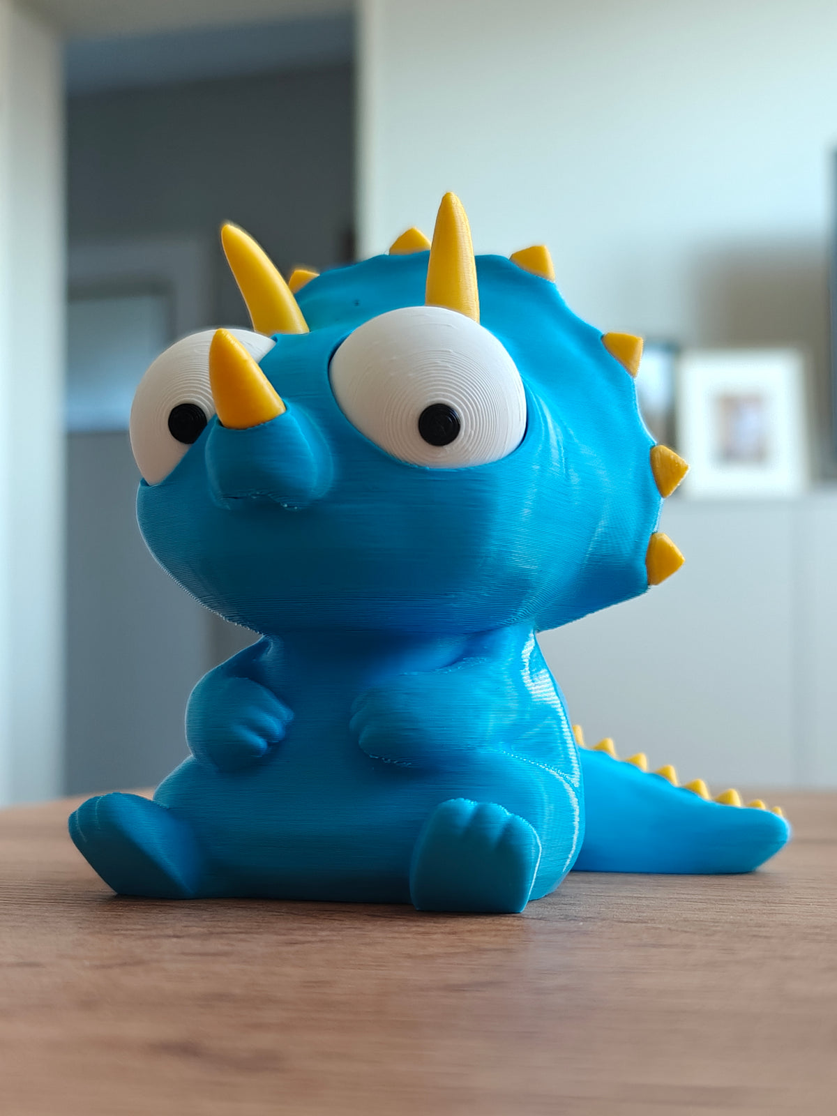 Figurine de tricératops rigolote aux yeux mobiles, gros plan sur fond blanc