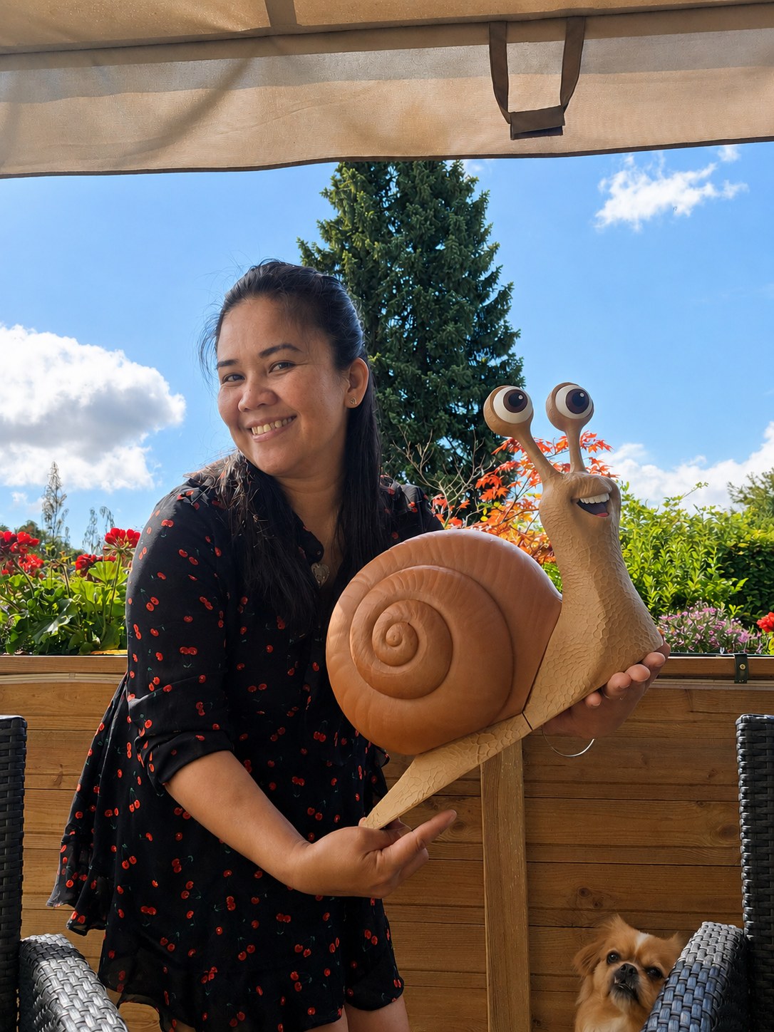 Personne tenant la grande statue d'escargot dans un jardin, pour montrer sa taille de 45 cm