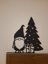 Figurine de lutin avec un cadeau au pied du sapin