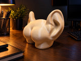 Figurine décorative fesses à oreilles vue de côté sur un bureau