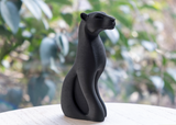 Sculpture de panthère noire sur un buffet en bois avec déco scandinave minimaliste