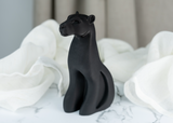 Détail d'une sculpture de panthère à la silhouette fluide en noir mat