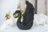 Sculpture de cygne noir sur une étagère minimaliste près de céramiques et d'une bougie