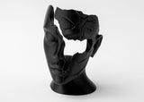Visage féminin abstrait fragmenté en sculpture sur une étagère en bois près d'objets en céramique mate