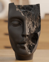 Gros plan de la sculpture abstraite de visage The Hollow Face, yeux fermés et cassures organiques