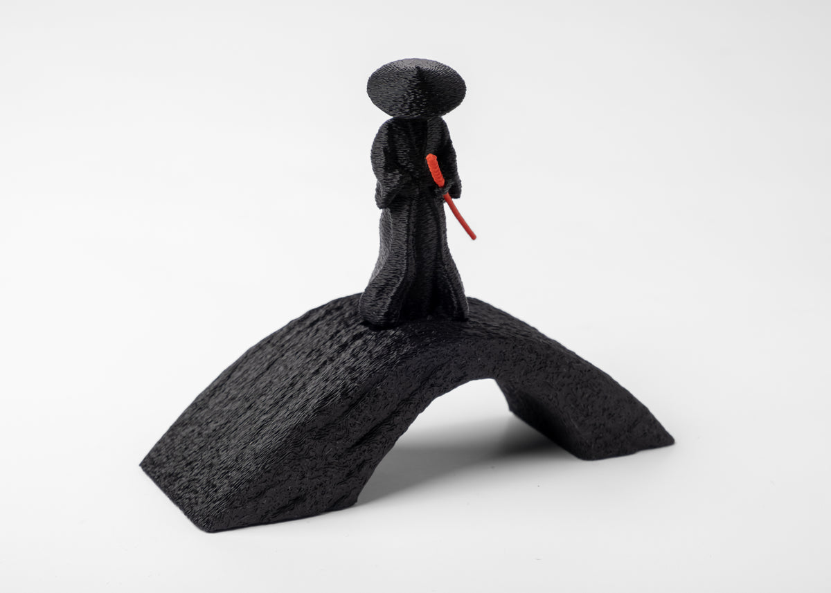 Sculpture de samouraï sur un bureau en bois avec de petits objets en céramique et naturels
