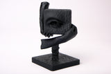 The Witness – sculpture surréaliste sur un bureau en bois sombre avec décoration minimaliste