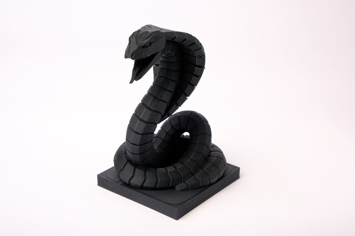 Sculpture de cobra sur un bureau en bois sombre avec déco minimaliste