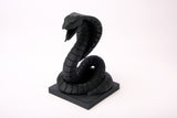 Sculpture de cobra sur un bureau en bois sombre avec déco minimaliste