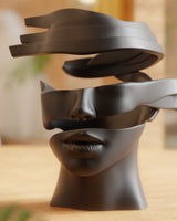 Sculpture abstraite de visage aux couches de rubans fragmentées sur fond blanc