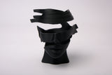 Sculpture surréaliste de visage abstrait sur une étagère minimaliste avec livres et plantes
