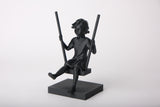Sculpture de fille sur une balançoire sur étagère en bois avec déco scandinave neutre
