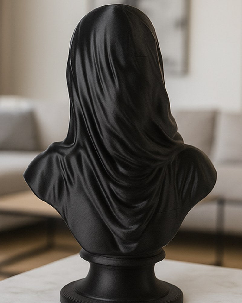 Buste voilé noir mat sur une surface blanche, gros plan sur le drapé du voile