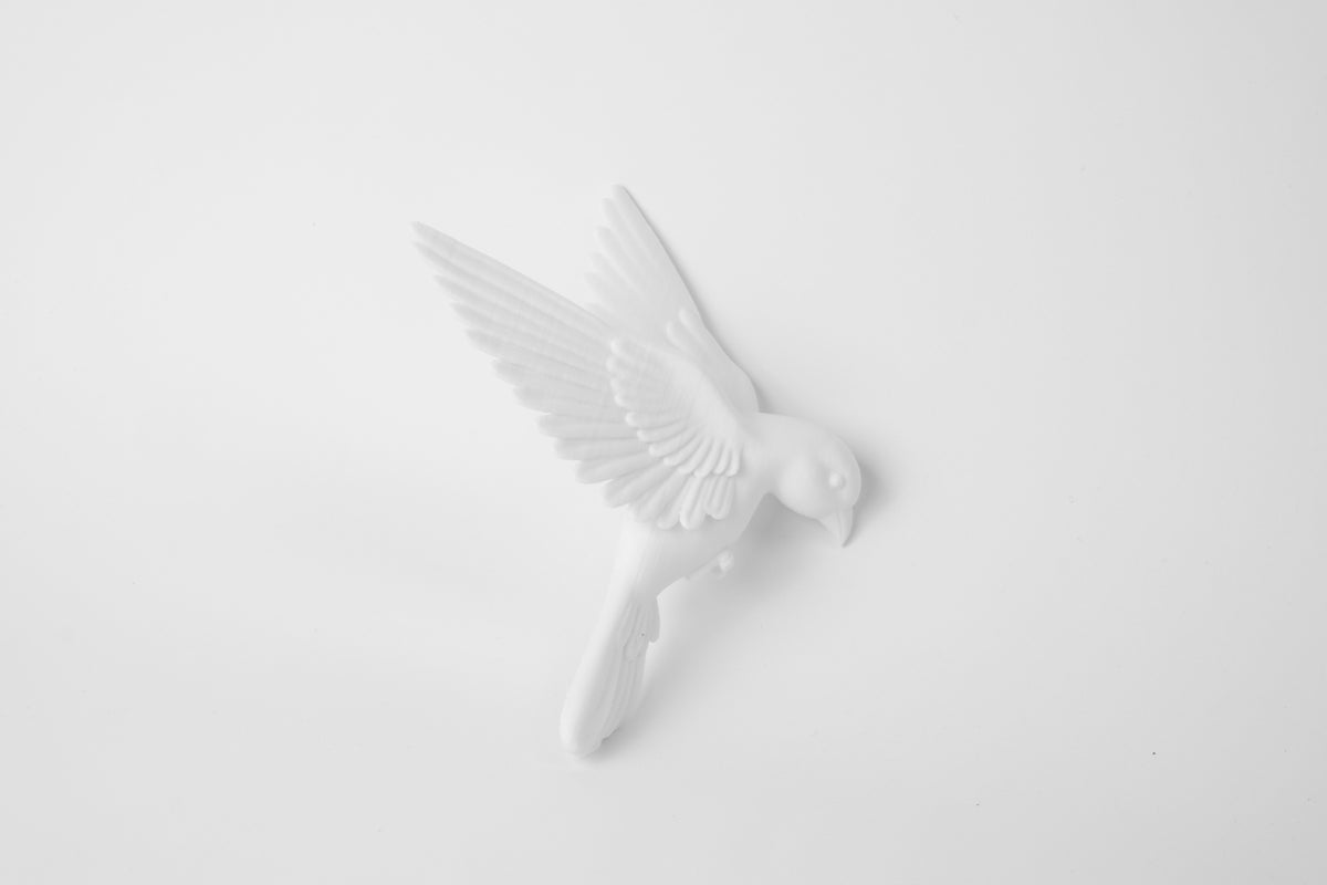 Gros plan d'une sculpture d'oiseau blanc mat à la texture d'ailes